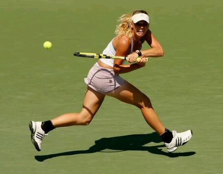 Caroline Wozniacki retourneert lopend de tennisbal